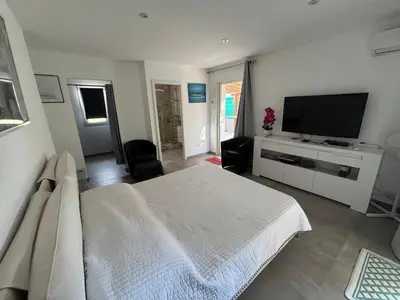 a bedroom with a white bed and a flat screen tv at villa Morgane in Calenzana