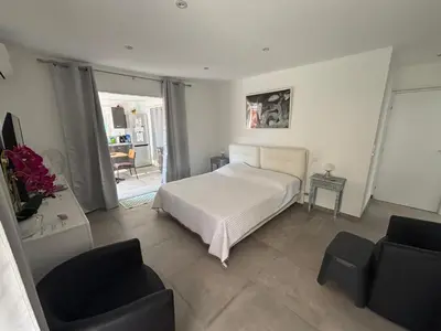 a bedroom with a white bed and two chairs at villa Morgane in Calenzana