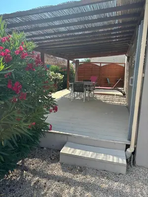 a wooden deck with a table and chairs on it at villa Morgane in Calenzana