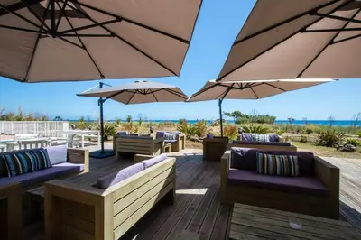 a patio with umbrellas and couches on a deck at Casa Verde Poggio Mezzana in Poggio-Mezzana