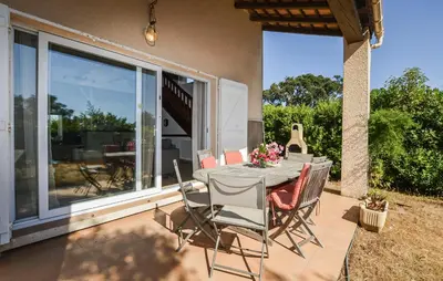 a table and chairs on a patio with windows at 2 Bedroom Gorgeous Home In Prunete in Prunete