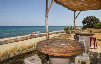 a table and chairs on the beach near the ocean at 2 Bedroom Gorgeous Home In Prunete in Prunete