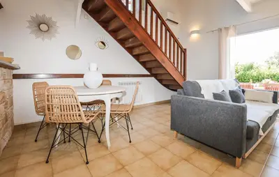 a living room with a table and chairs and a staircase at 2 Bedroom Gorgeous Home In Prunete in Prunete
