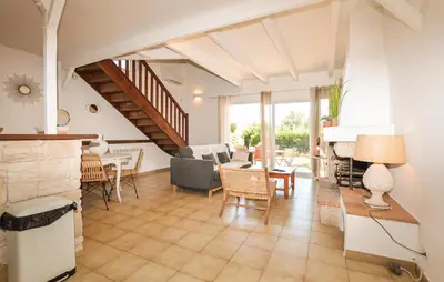 a living room with a fireplace and a table and chairs at 2 Bedroom Gorgeous Home In Prunete in Prunete