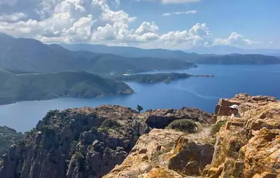 a person standing on top of a mountain overlooking a body of water at Cozy Apartment In Piana in Piana