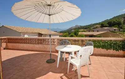 a table and chairs with an umbrella on a patio at Cozy Apartment In Piana in Piana