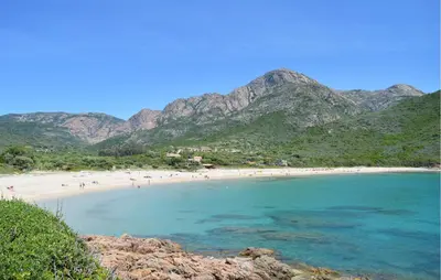 a group of people on a beach with mountains in the background at Cozy Apartment In Piana in Piana