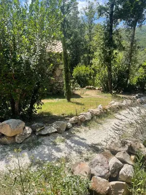 a stone retaining wall next to a stone house at LA PAUSE - 3 villas avec Jacuzzi privatif à chisà in Chisa
