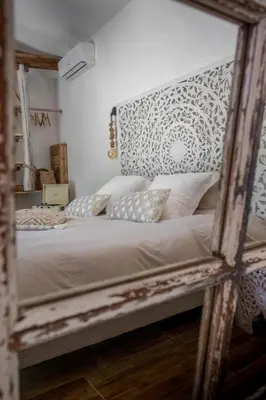 a mirror reflection of a bed in a bedroom at LA PAUSE - 3 villas avec Jacuzzi privatif à chisà in Chisa