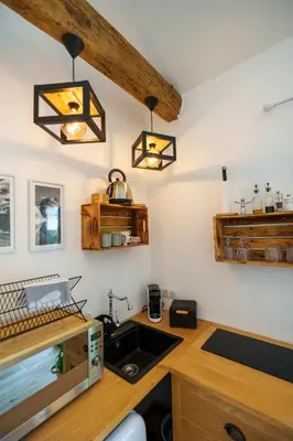 a kitchen with a sink and two lights on the wall at LA PAUSE - 3 villas avec Jacuzzi privatif à chisà in Chisa