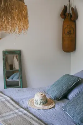 a hat on top of a bed with a mirror at LA PAUSE - 3 villas avec Jacuzzi privatif à chisà in Chisa