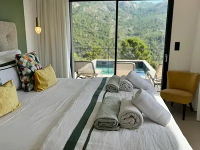 a hotel room with a bed with towels on it at Villa neuve perchée - Vue splendide in Zonza