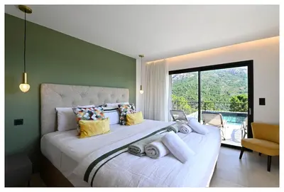 a bedroom with a large white bed with a large window at Villa neuve perchée - Vue splendide in Zonza