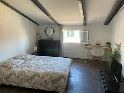 a bedroom with a bed and a desk and a window at Studio Ajaccio Centre in Ajaccio