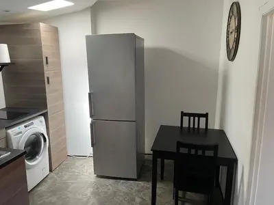 a kitchen with a table and a refrigerator at Studio Ajaccio Centre in Ajaccio