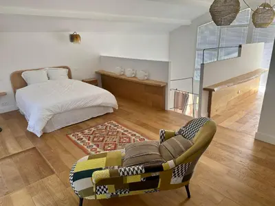 a bedroom with a bed and a couch and a chair at Villa au bord de mer Bonifacio in Bonifacio