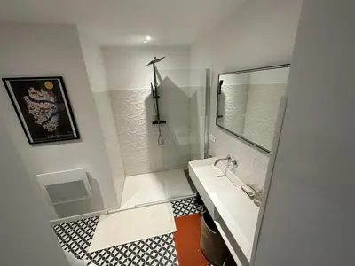 a white bathroom with a sink and a mirror at Villa au bord de mer Bonifacio in Bonifacio