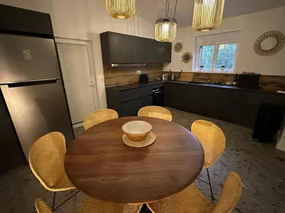a kitchen with a wooden table and some chairs at Villa au bord de mer Bonifacio in Bonifacio