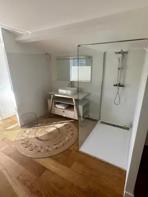 a bathroom with a glass shower and a sink at Villa au bord de mer Bonifacio in Bonifacio