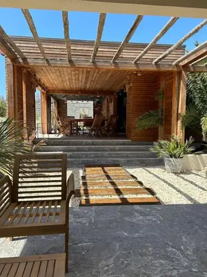 a wooden patio with a bench and a table at Villa au bord de mer Bonifacio in Bonifacio