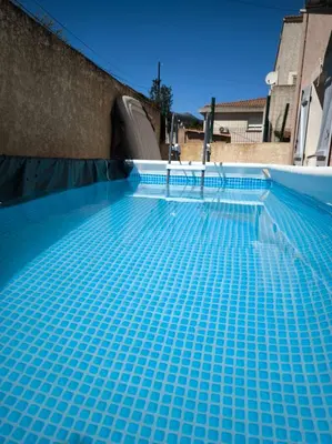 a swimming pool with blue tiles on it at Sud Bastia 50 m2 privé avec jacuzzi et piscine in Monte