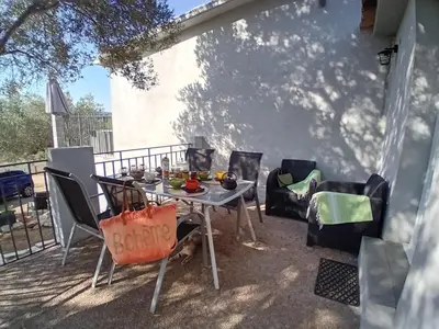 a table and chairs sitting on a patio at La maison sous les oliviers Casa d'Iloa in Porto-Vecchio