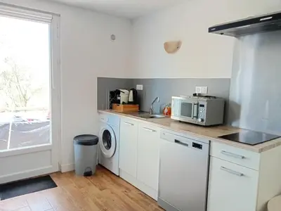 a kitchen with a washing machine and a microwave at La maison sous les oliviers Casa d'Iloa in Porto-Vecchio