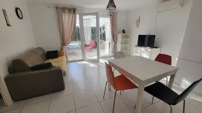 a living room with a table and a couch at Escape and comfort near Ajaccio, beautiful 2 bedroom terrace in Alata
