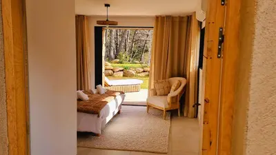 a bedroom with a bed and a chair and a window at Domaine de Gialla Bergerie I Pini, 2 pers, piscine chauffée, 10 mn plage in Arraggio