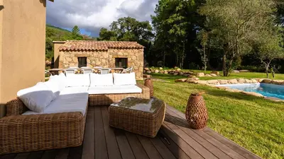 a wicker couch and chairs sitting on a wooden deck at Domaine de Gialla Bergerie I Pini, 2 pers, piscine chauffée, 10 mn plage in Arraggio
