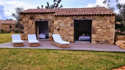 a stone house with two chairs and a deck at Domaine de Gialla Bergerie I Pini, 6 pers, piscine chauffée, 10 mn plage in Arraggio