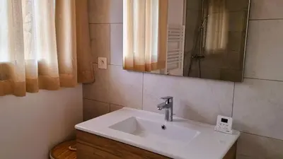 a bathroom with a white sink and a mirror at Domaine de Gialla Bergerie I Pini, 6 pers, piscine chauffée, 10 mn plage in Arraggio