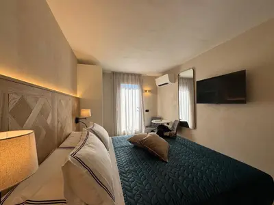 a bedroom with a bed and a television on the wall at B&B Les Capitaineries in Bonifacio