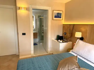 a bedroom with a bed and a walk in shower at B&B Les Capitaineries in Bonifacio
