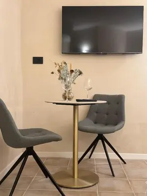 two chairs and a table with a vase of flowers at B&B Les Capitaineries in Bonifacio