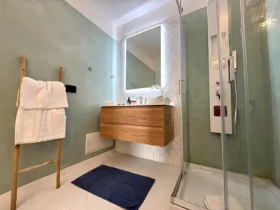 a bathroom with a shower and a sink and a mirror at B&B Les Capitaineries in Bonifacio
