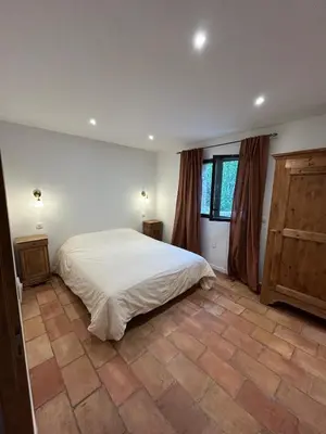a bedroom with a white bed and a window at Casa Scaledda in Bocognano