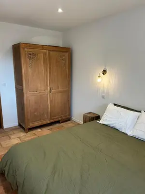 a bedroom with a bed and a wooden cabinet at Casa Scaledda in Bocognano