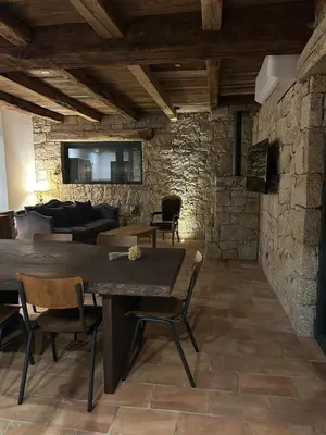 a living room with a wooden table and chairs at Casa Scaledda in Bocognano