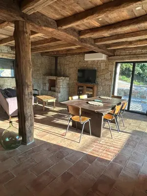 a living room with a table and chairs and a couch at Casa Scaledda in Bocognano