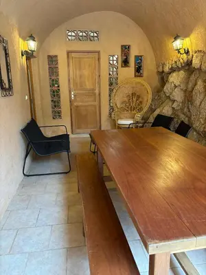 a dining room with a wooden table and chairs at Appartement Spacieux Vue Montagne- Parking gratuit- Proche ÎLE ROUSSE in Belgodère