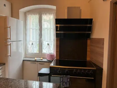 a kitchen with a stove and a white refrigerator at Appartement Spacieux Vue Montagne- Parking gratuit- Proche ÎLE ROUSSE in Belgodère