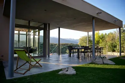 a house with a patio with a table and chairs at Magnifique villa avec piscine chauffée, vue mer et montage in Porto-Vecchio