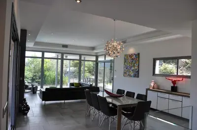 a dining room and living room with a chandelier at Magnifique villa avec piscine chauffée, vue mer et montage in Porto-Vecchio