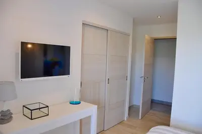 a living room with a tv on a white wall at Magnifique villa avec piscine chauffée, vue mer et montage in Porto-Vecchio