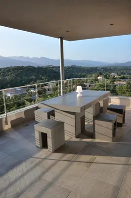 a table and benches on a balcony with a view at Magnifique villa avec piscine chauffée, vue mer et montage in Porto-Vecchio