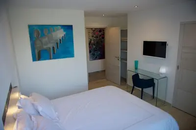 a bedroom with a white bed and a desk at Magnifique villa avec piscine chauffée, vue mer et montage in Porto-Vecchio