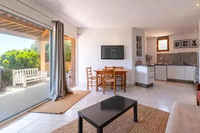 a living room with a table and a kitchen at Casa di Ruppione - Magnifique Vue Mer in Pietrosella