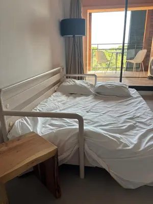 a bed in a room with a table and a window at Superbe T2 les pieds dans l'eau in Pianottoli-Caldarello