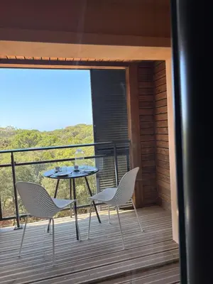 a patio with a table and chairs on a balcony at Superbe T2 les pieds dans l'eau in Pianottoli-Caldarello